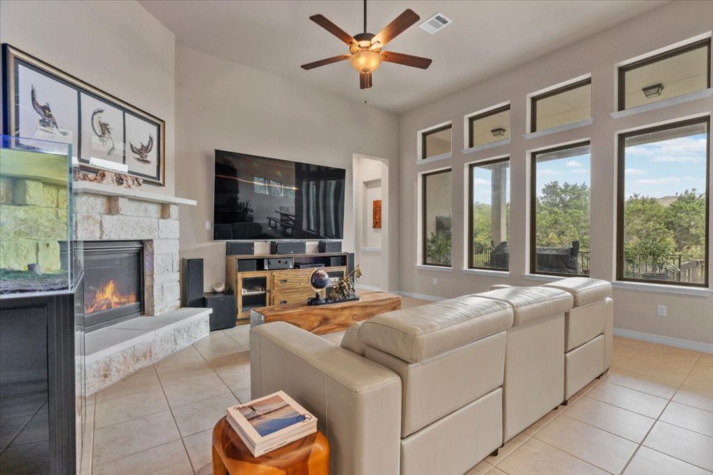 6705 Destination Way Jonestown, TX 78645 - Photo 6 of 39 This expansive living room has an incredible wall of windows that frame the lush greenery outside.