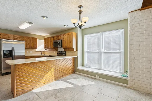 a view of a kitchen with stainless steel appliances granite countertop cabinets and a floor to ceiling window