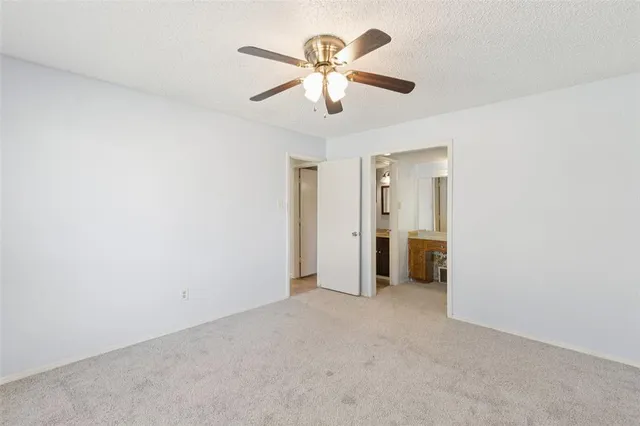 an empty room with ceiling fan and window