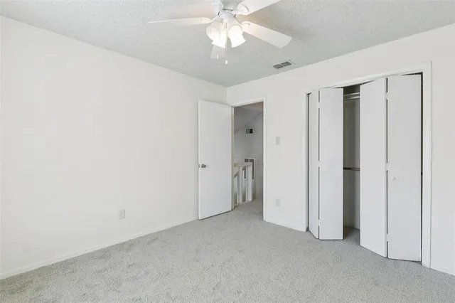 a view of an empty room and chandelier fan