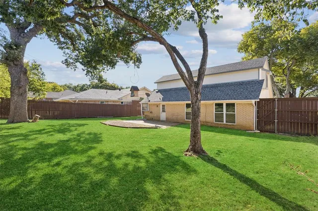 a view of a house with backyard and a tree
