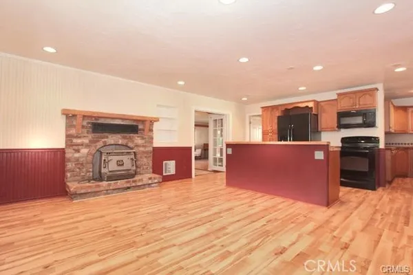 a kitchen with stainless steel appliances kitchen island granite countertop a stove and a refrigerator with wooden floor