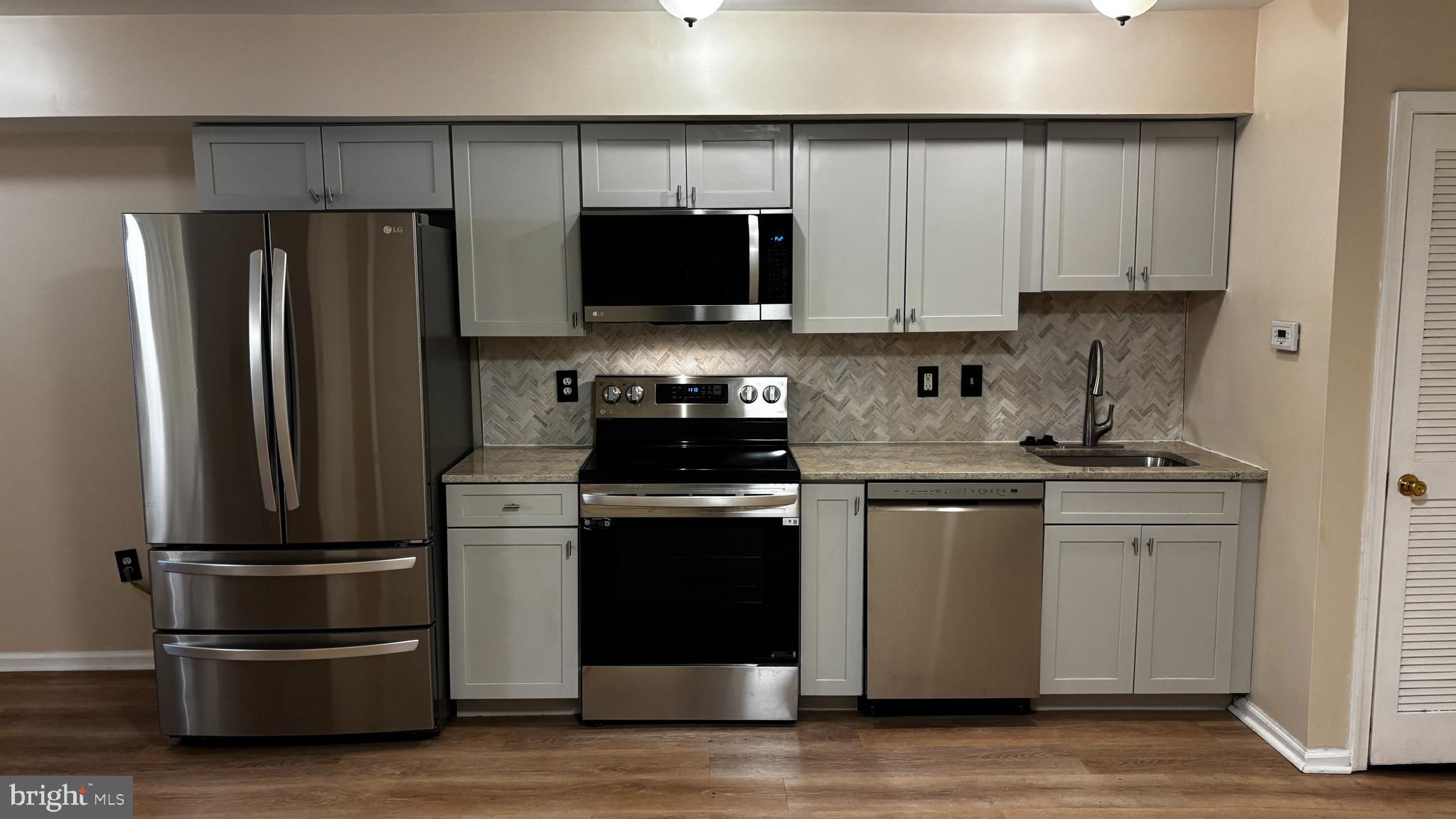 1240 18th Street Northeast, Unit 2 Washington, DC 20002 - Photo 2 of 11 a kitchen with stainless steel appliances and wooden cabinets