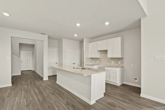 a large kitchen with a sink and cabinets