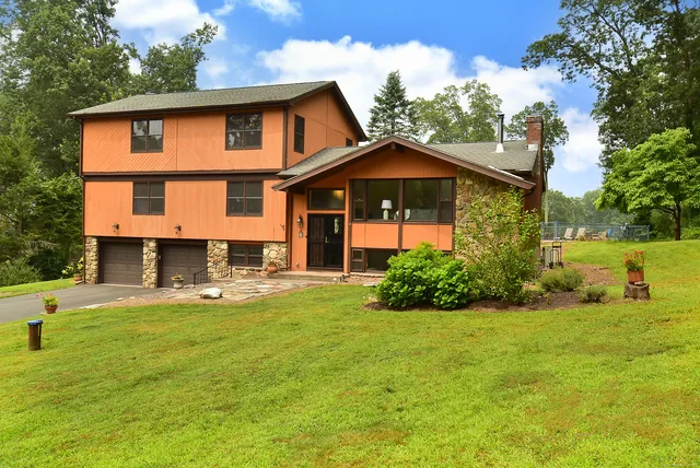 a front view of a house with yard and green space