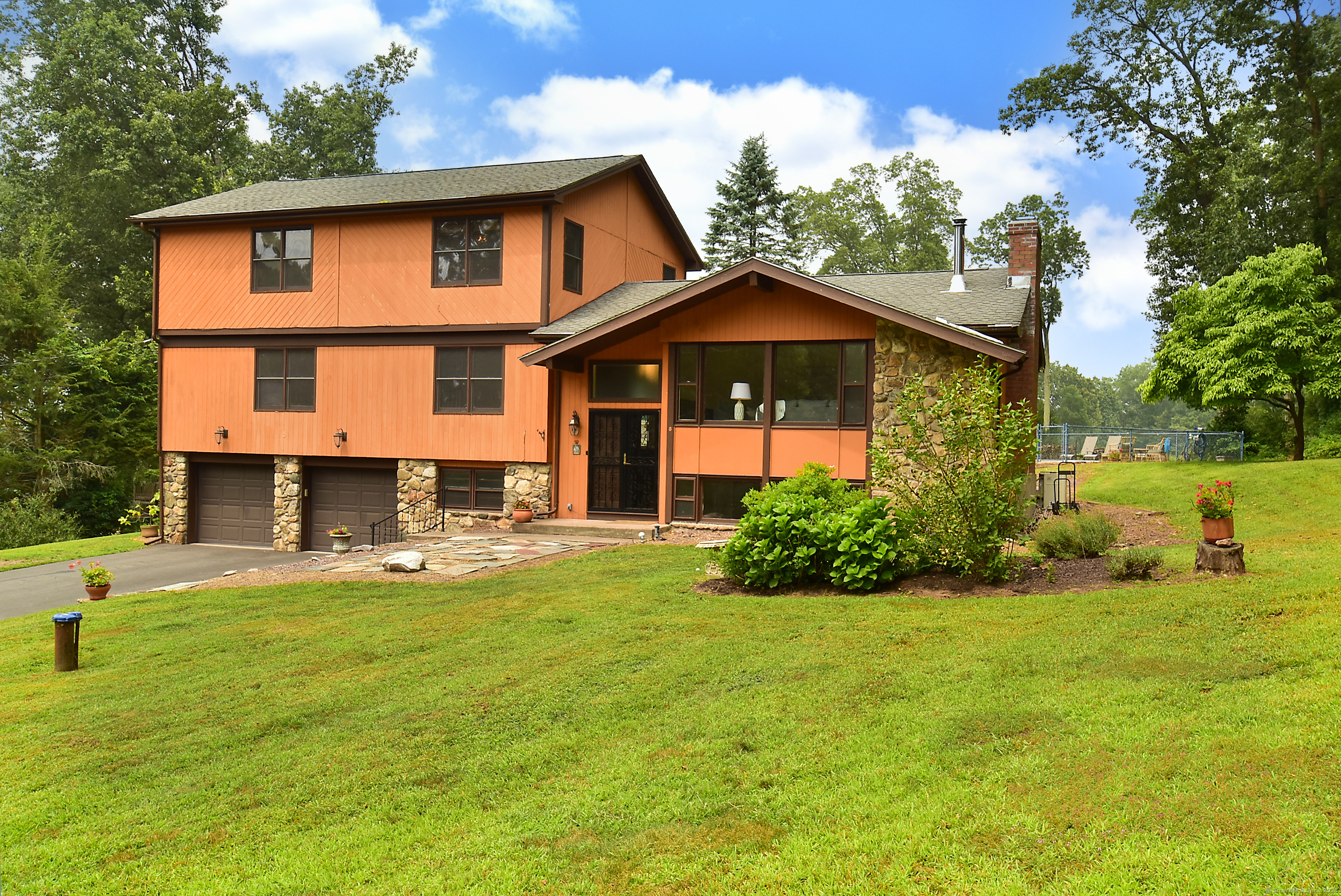 a front view of a house with yard and green space