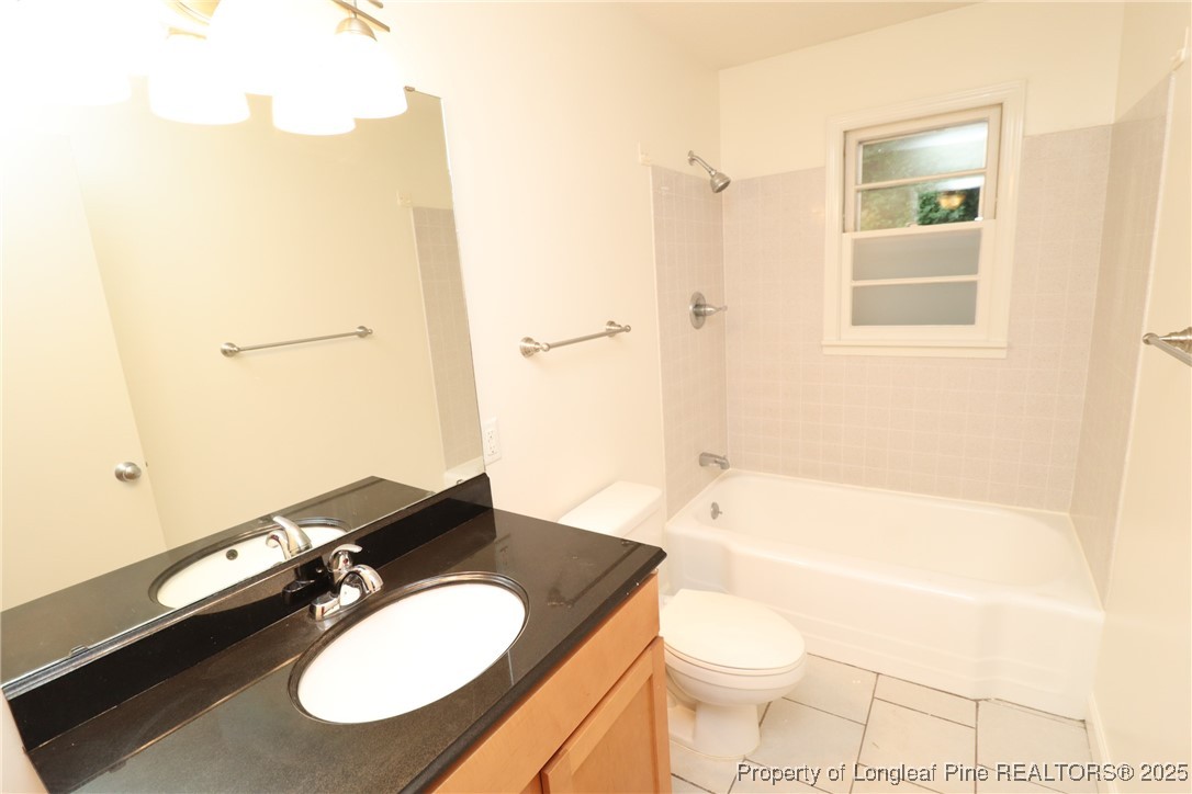 1426 Trinity Circle Raleigh, NC 27607 - Photo 31 of 31 a bathroom with a granite countertop toilet sink and mirror