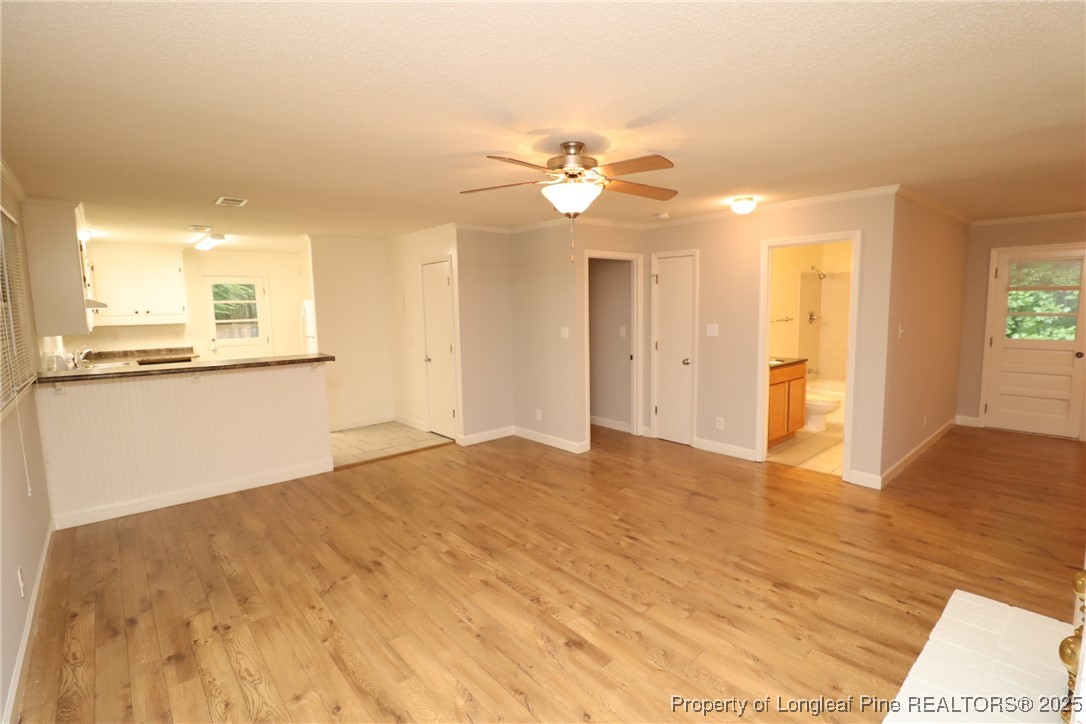 1426 Trinity Circle Raleigh, NC 27607 - Photo 4 of 31 a view of a kitchen with wooden floor and a ceiling fan