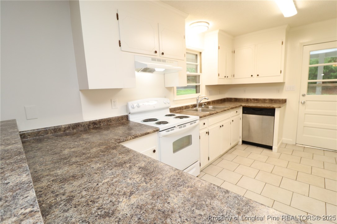 1426 Trinity Circle Raleigh, NC 27607 - Photo 10 of 31 a white kitchen with granite countertop a stove a sink and white cabinets
