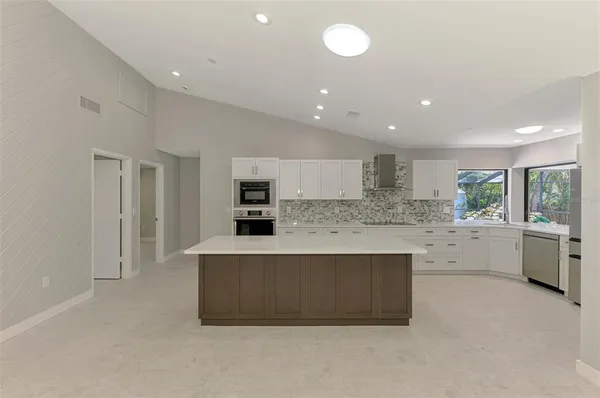 a large kitchen with stainless steel appliances granite countertop a large counter top and a stove