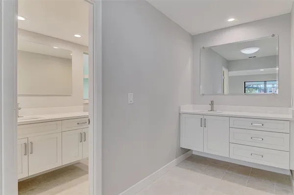 a bathroom with a sink a toilet a mirror and shower