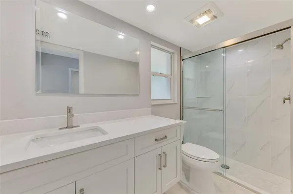 a spacious bathroom with a shower sink and mirror