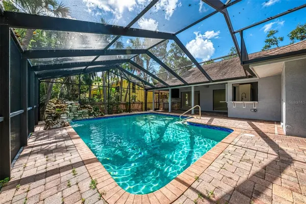 a view of a swimming pool with a table and chairs under an umbrella