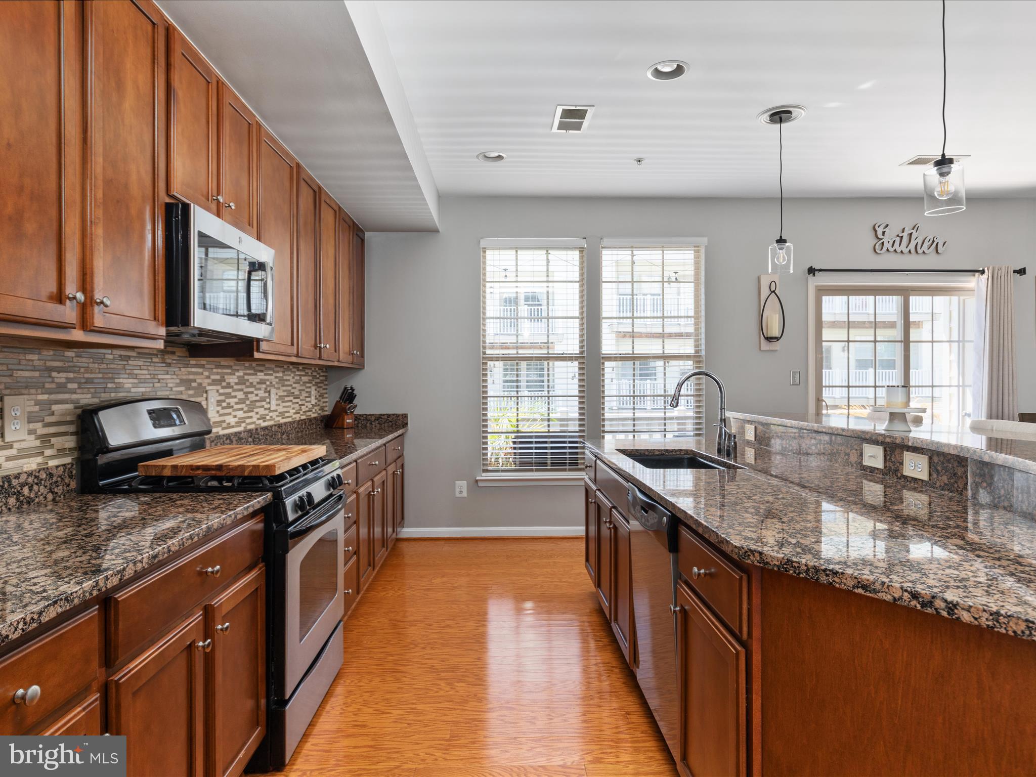 7734 Cedar Branch Drive Gainesville, VA 20155 - Photo 13 of 62 a kitchen with stainless steel appliances granite countertop a sink stove and cabinets