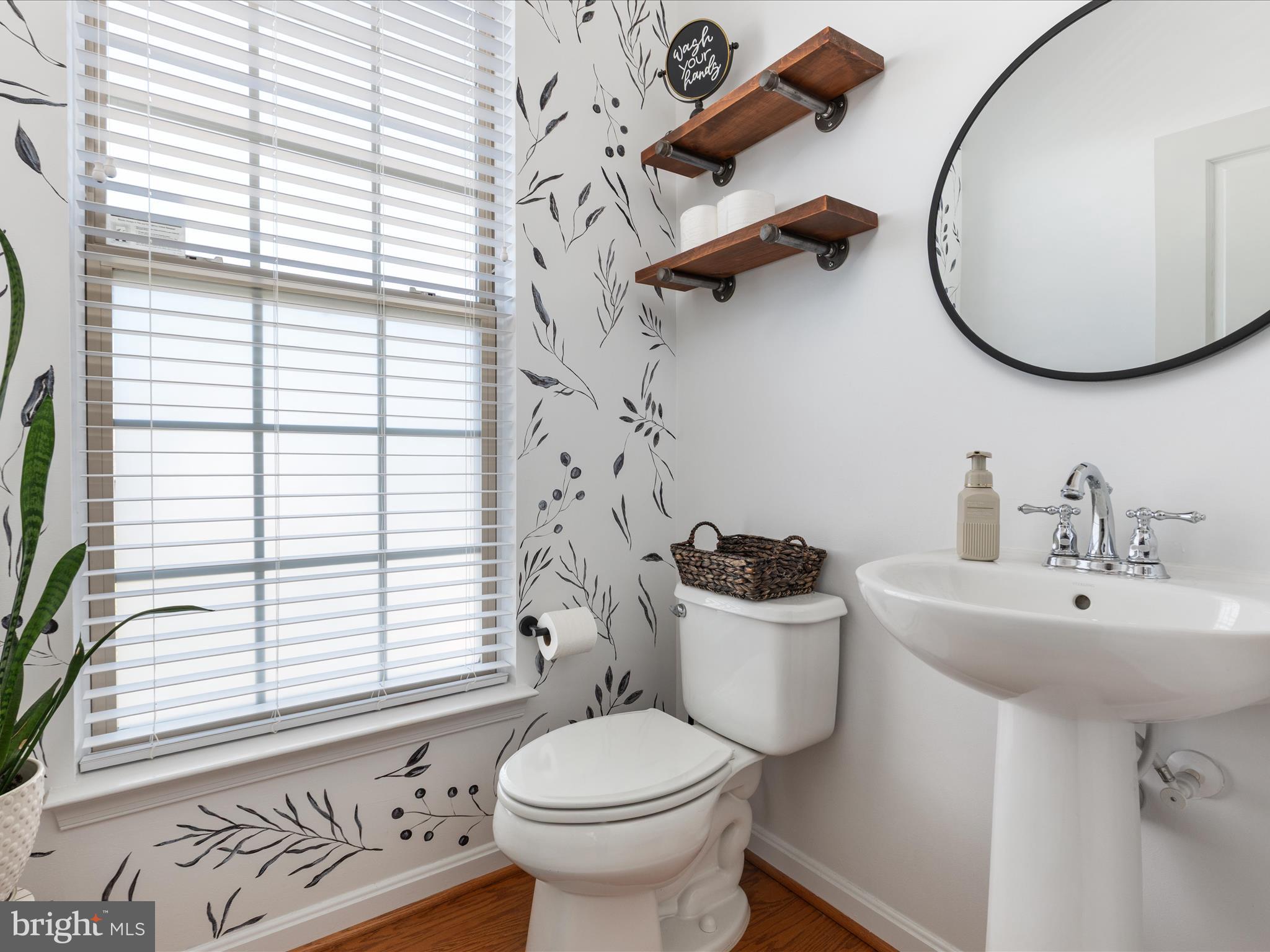 7734 Cedar Branch Drive Gainesville, VA 20155 - Photo 15 of 62 a bathroom with a sink a mirror a toilet and a window