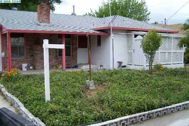 a view of a house with potted plants and a table