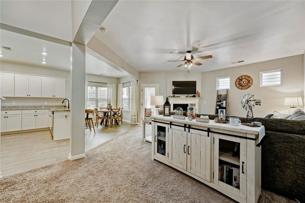 153 Bryon Lane Acworth, GA 30102 - Photo 4 of 25 a kitchen with stainless steel appliances a stove a sink dishwasher and a fireplace with wooden floor