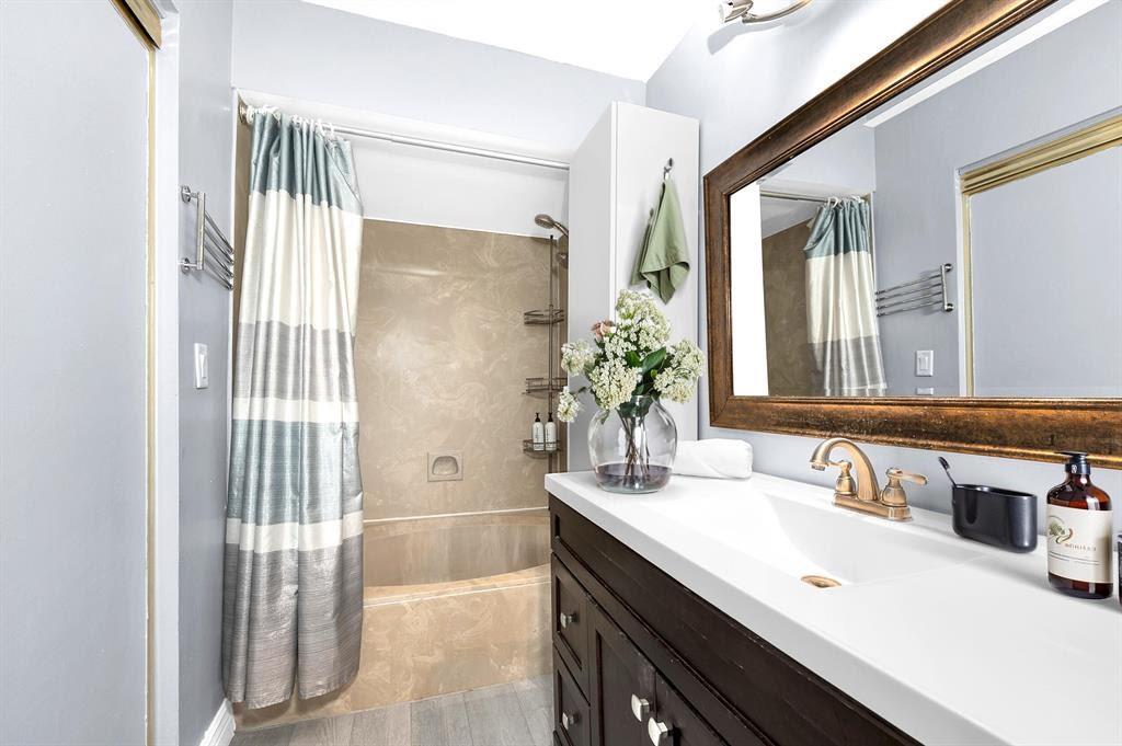 9355 Southwest 8th Street, Unit 401 Boca Raton, FL 33428 - Photo 12 of 37 a bathroom with a sink a mirror and a shower