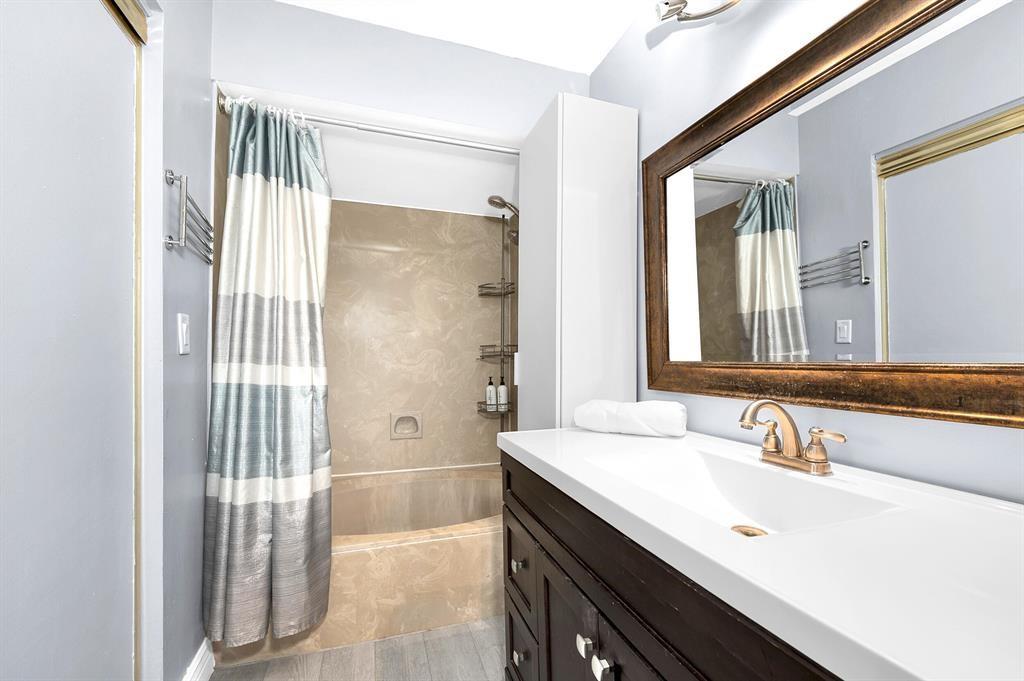 9355 Southwest 8th Street, Unit 401 Boca Raton, FL 33428 - Photo 33 of 37 a bathroom with a sink a mirror and a shower