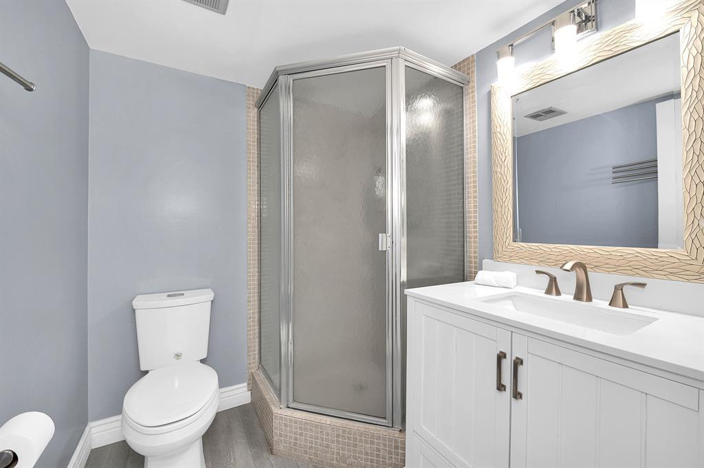 9355 Southwest 8th Street, Unit 401 Boca Raton, FL 33428 - Photo 35 of 37 a bathroom with a toilet sink and mirror