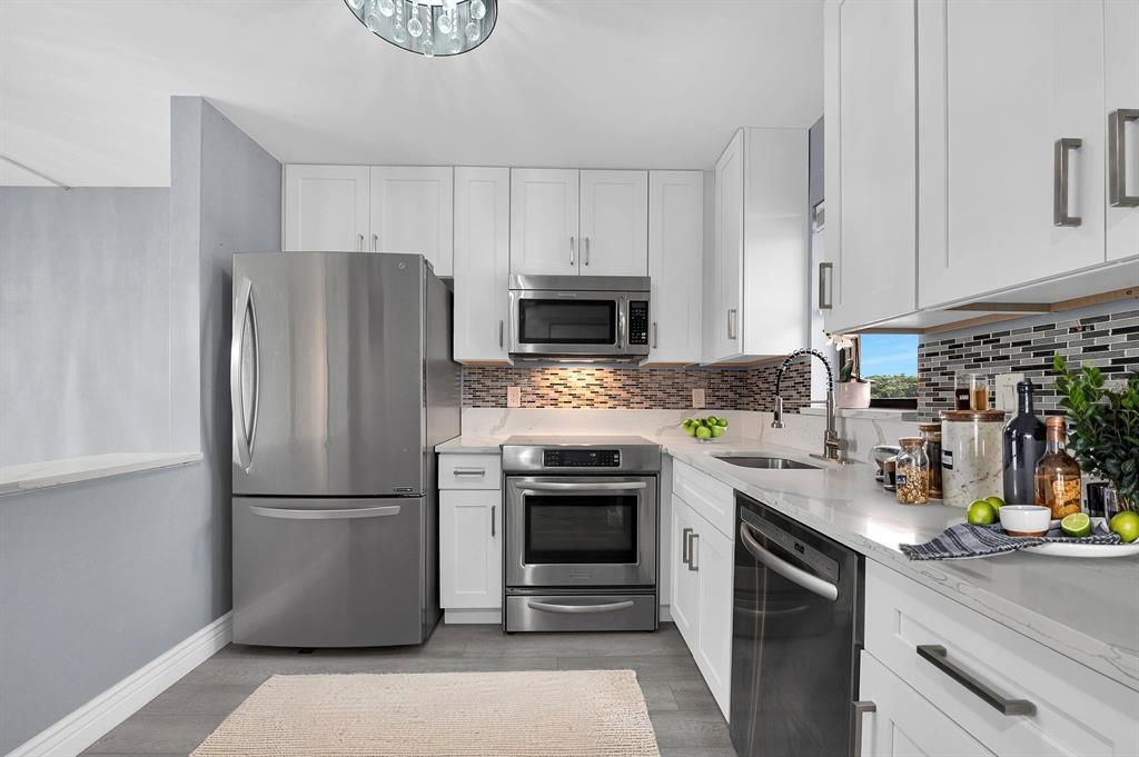 9355 Southwest 8th Street, Unit 401 Boca Raton, FL 33428 - Photo 6 of 37 a kitchen with a refrigerator sink and cabinets