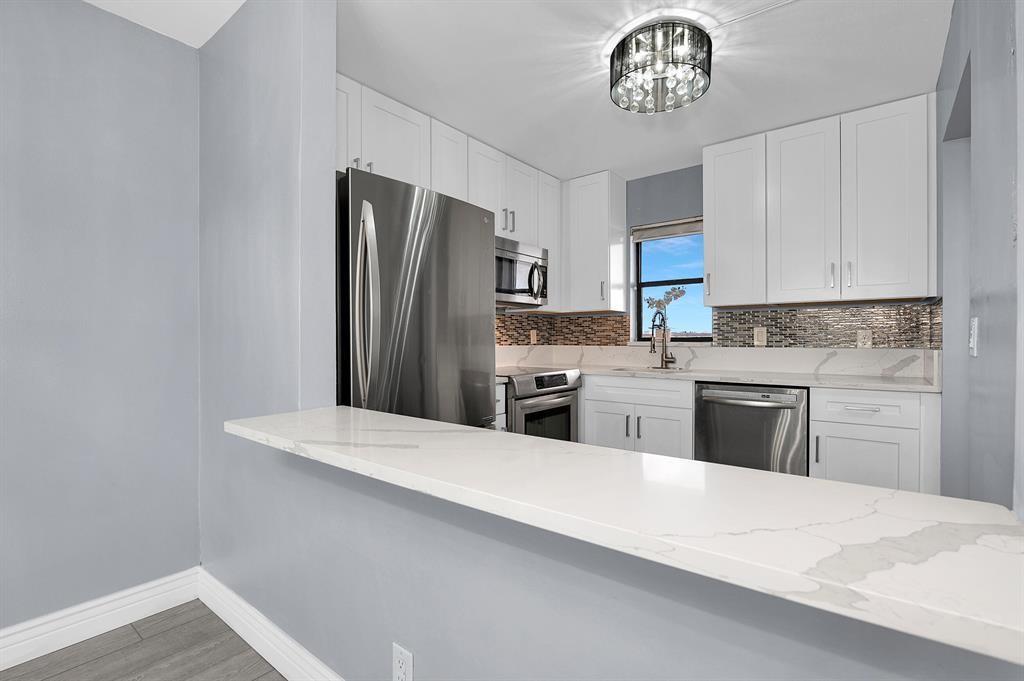 9355 Southwest 8th Street, Unit 401 Boca Raton, FL 33428 - Photo 8 of 37 a kitchen with stainless steel appliances a refrigerator sink and stove