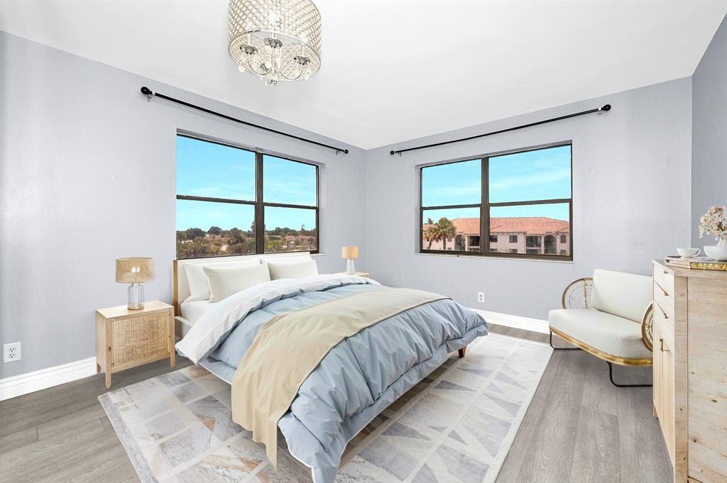 9355 Southwest 8th Street, Unit 401 Boca Raton, FL 33428 - Photo 10 of 37 a bedroom with a bed and a large window