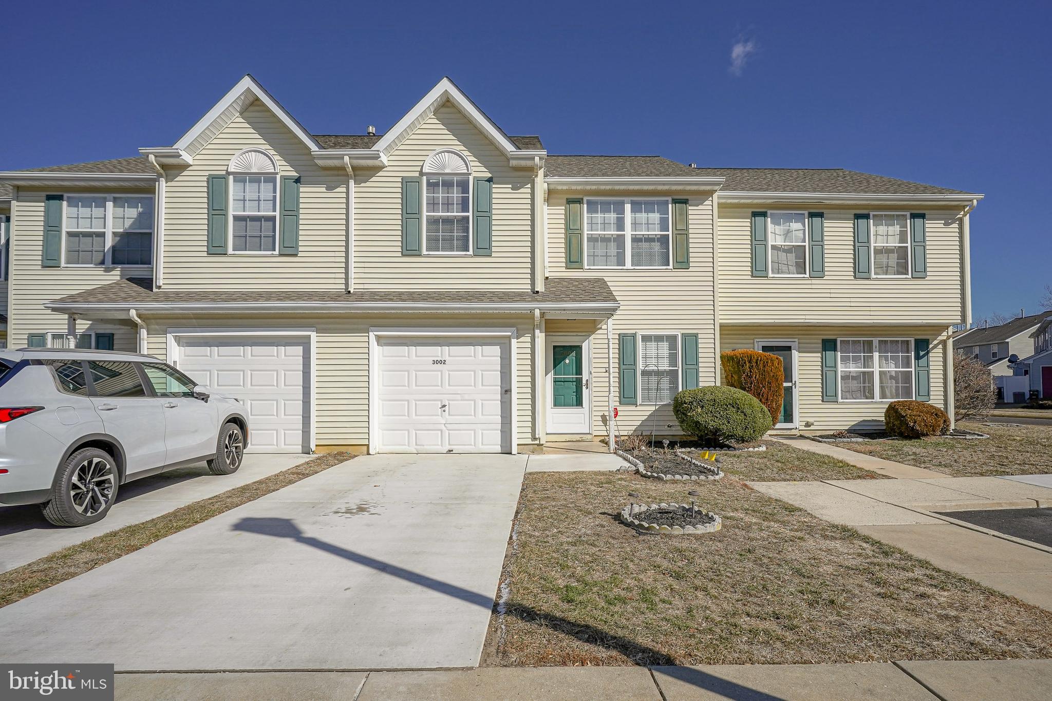 a front view of a house with cars parked