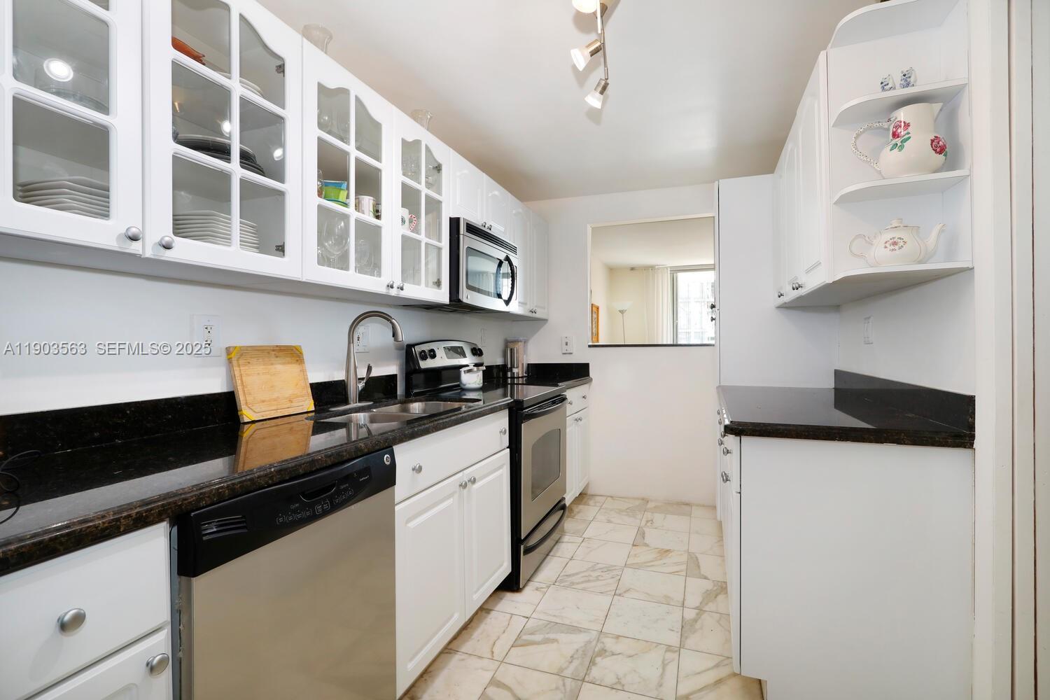 145 Southeast 25th Road, Unit 702 Miami, FL 33129 - Photo 5 of 27 a kitchen with stainless steel appliances a sink and a stove