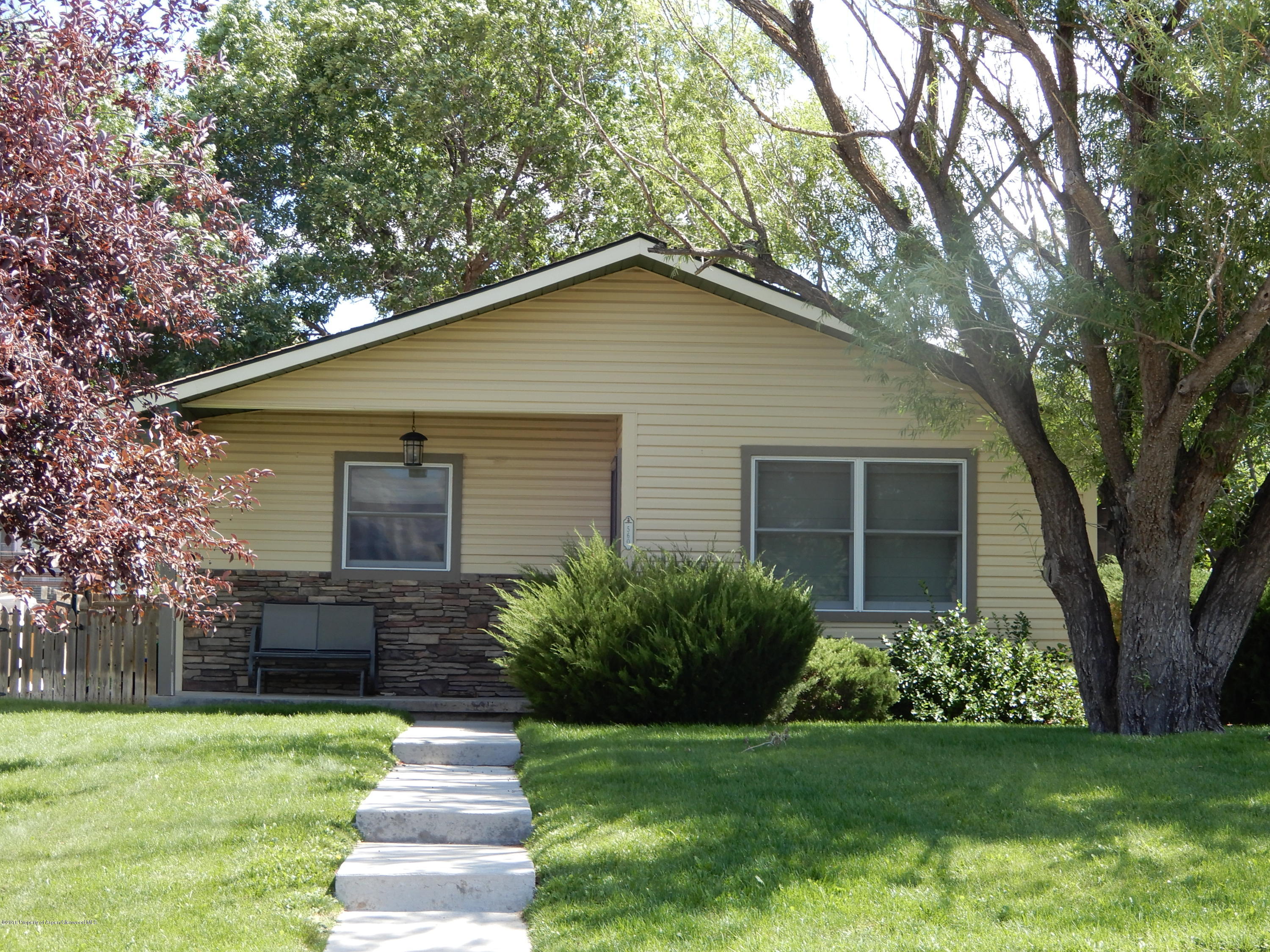 560 Will Avenue Rifle, CO 81650 - Photo 1 of 18 a front view of a house with a yard and trees