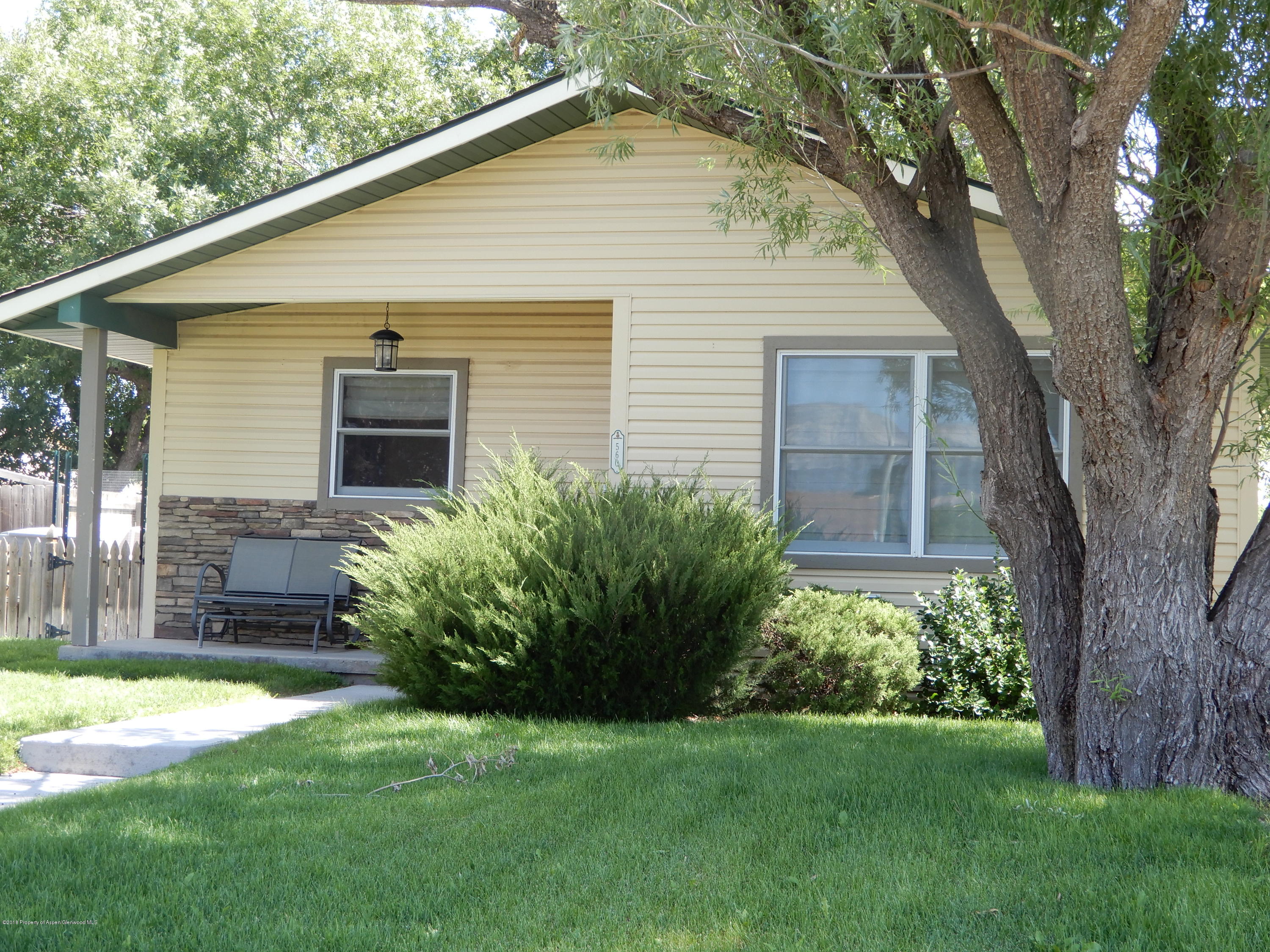 560 Will Avenue Rifle, CO 81650 - Photo 4 of 18 a backyard of a house with plants and large tree