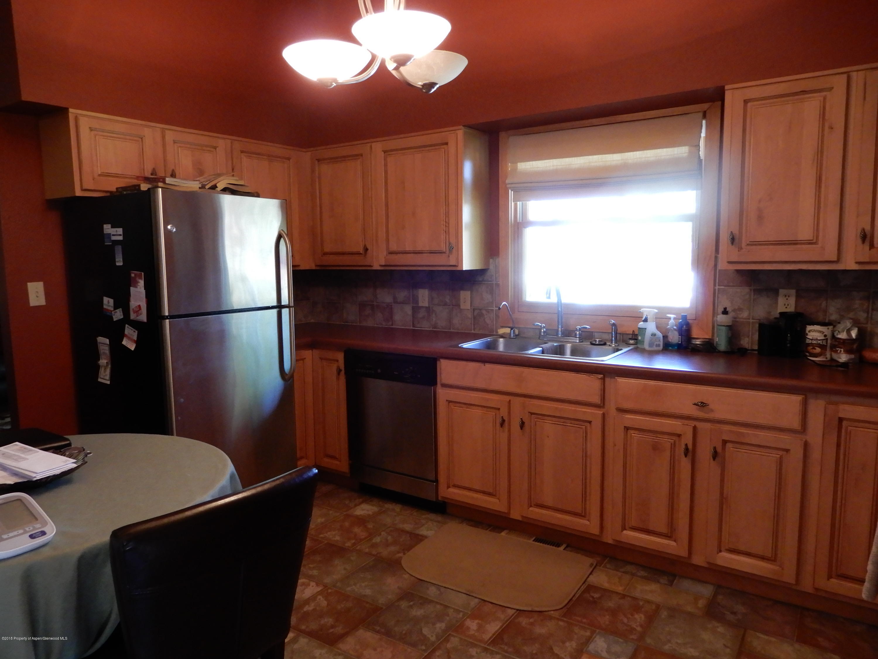 560 Will Avenue Rifle, CO 81650 - Photo 8 of 18 a kitchen with stainless steel appliances granite countertop a refrigerator sink and cabinets