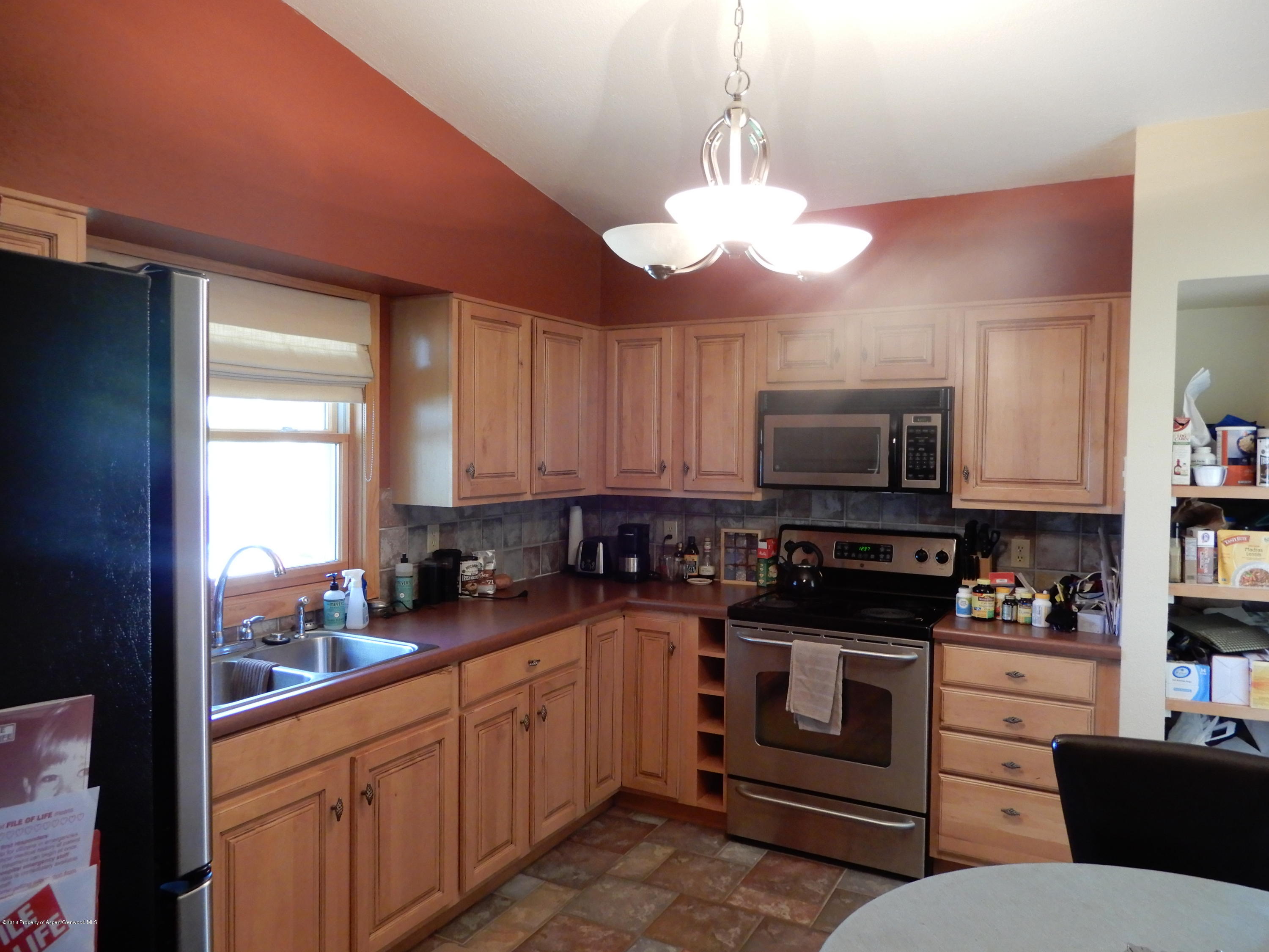 560 Will Avenue Rifle, CO 81650 - Photo 9 of 18 a kitchen with stainless steel appliances a stove a sink and a refrigerator