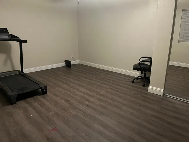 a room with wooden floor and gym equipment
