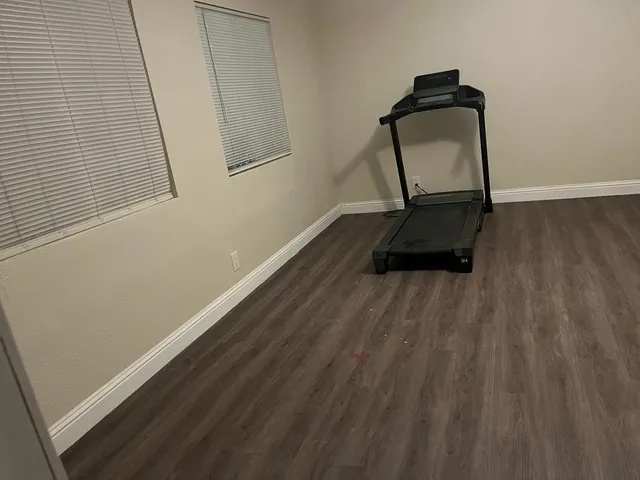 a room with wooden floor and mirror