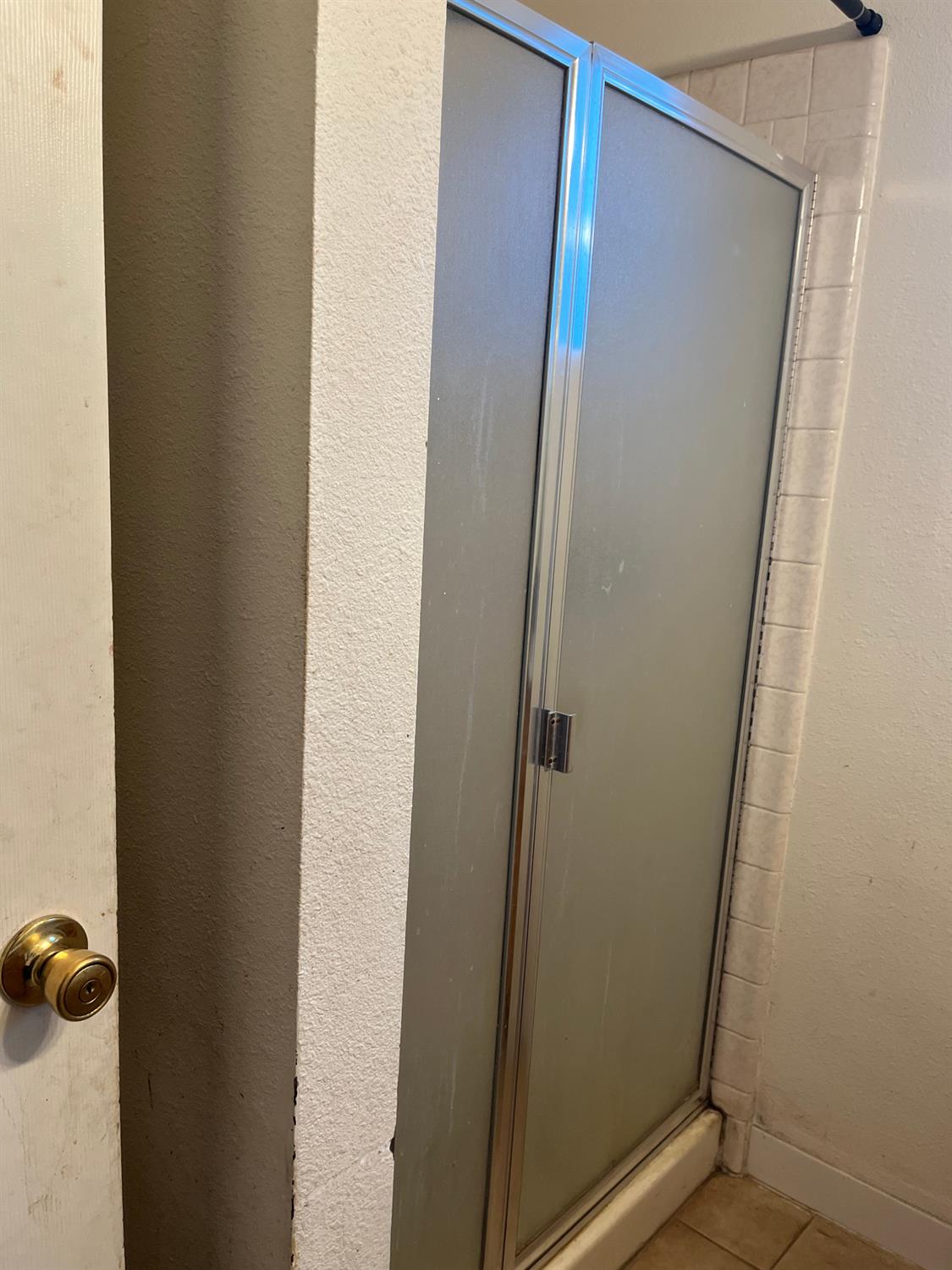 800 Wessmith Way Madera, CA 93638 - Photo 19 of 24 a bathroom with a glass shower door