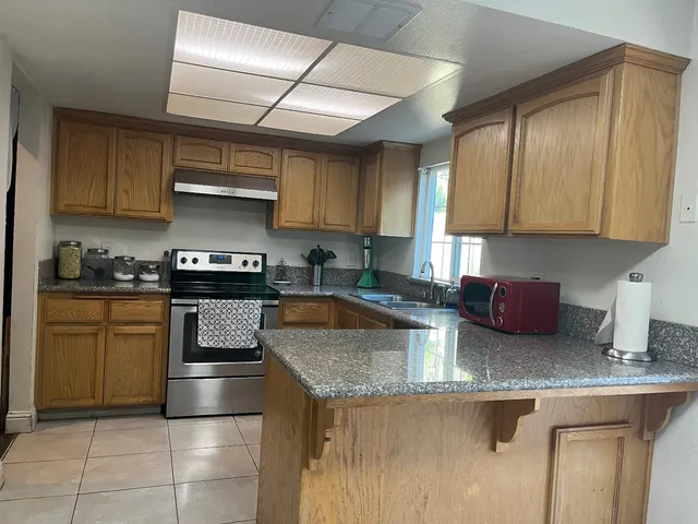 a kitchen with stainless steel appliances granite countertop a sink stove and refrigerator