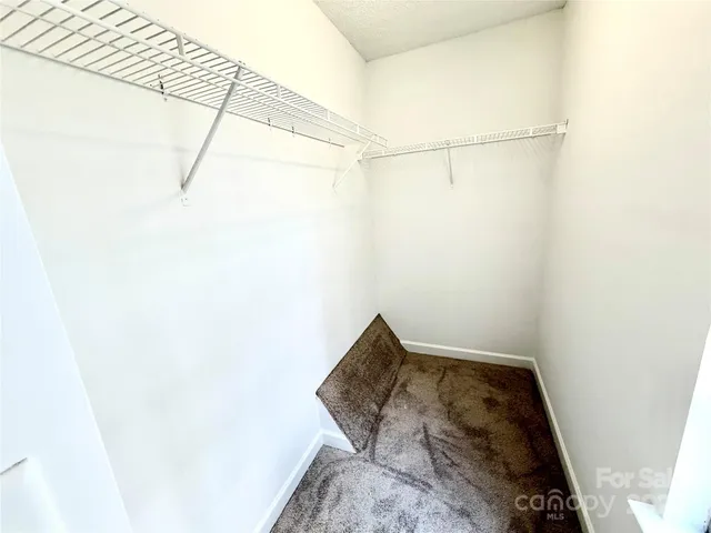 an empty room with closet and windows