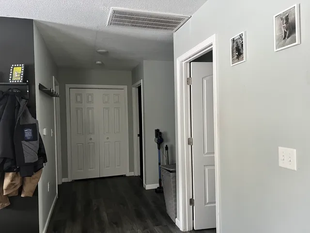 a view of a hallway with closet and wooden floor