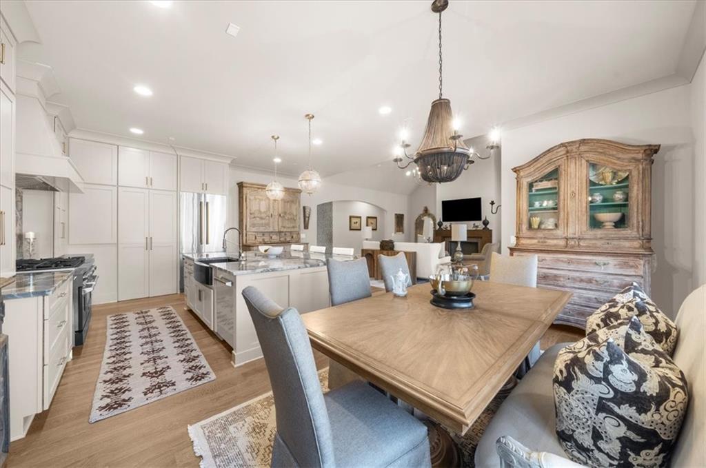 9773 Hightower Road Roswell, GA 30075 - Photo 21 of 79 a dining room with wooden floor a chandelier a wooden table and chairs