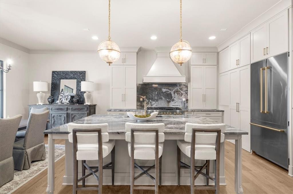 9773 Hightower Road Roswell, GA 30075 - Photo 23 of 79 a kitchen with stainless steel appliances a dining table chairs and white cabinets
