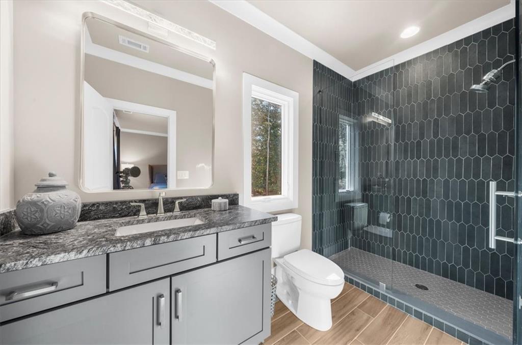 9773 Hightower Road Roswell, GA 30075 - Photo 54 of 79 a bathroom with a granite countertop sink toilet mirror and shower
