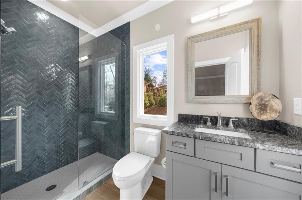 9773 Hightower Road Roswell, GA 30075 - Photo 57 of 79 a bathroom with a granite countertop toilet a sink and a mirror