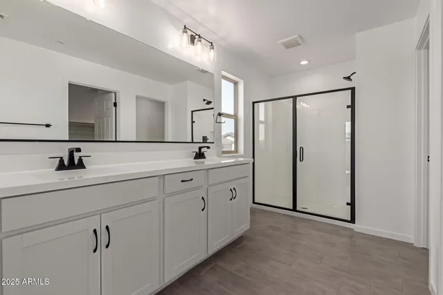 a spacious bathroom with a double vanity sink and mirror