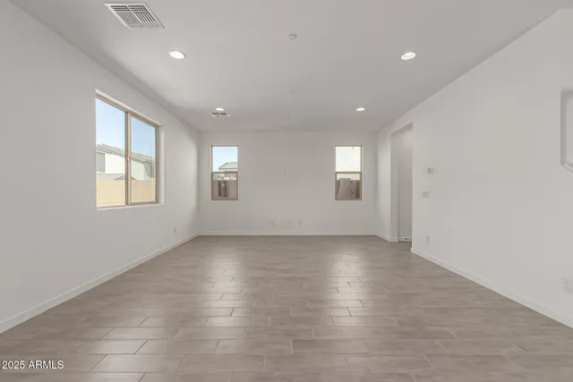 a view of an empty room with windows and closet