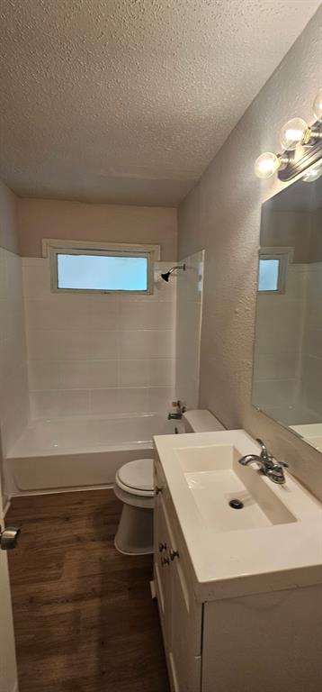 5170 Cardiff Street Dallas, TX 75241 - Photo 8 of 14 Bathroom featuring a textured ceiling, vanity, toilet, a textured wall, and wood finished floors
