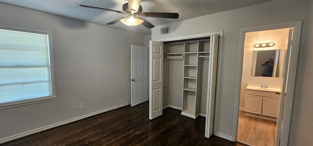 5170 Cardiff Street Dallas, TX 75241 - Photo 10 of 14 Unfurnished bedroom with dark wood finished floors, a textured ceiling, a closet, a sink, and ceiling fan