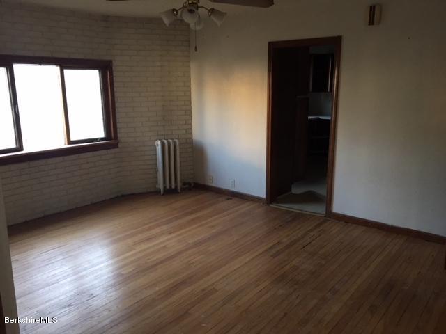 156 Elizabeth Street Pittsfield, MA 01201 - Photo 2 of 9 an empty room with wooden floor and windows
