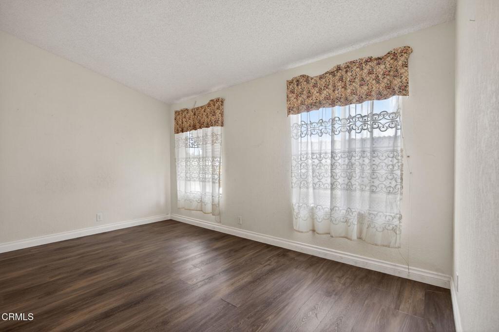 2177 Robin Avenue, Unit 2177A Oxnard, CA 93033 - Photo 20 of 29 a view of an empty room with wooden floor and a window