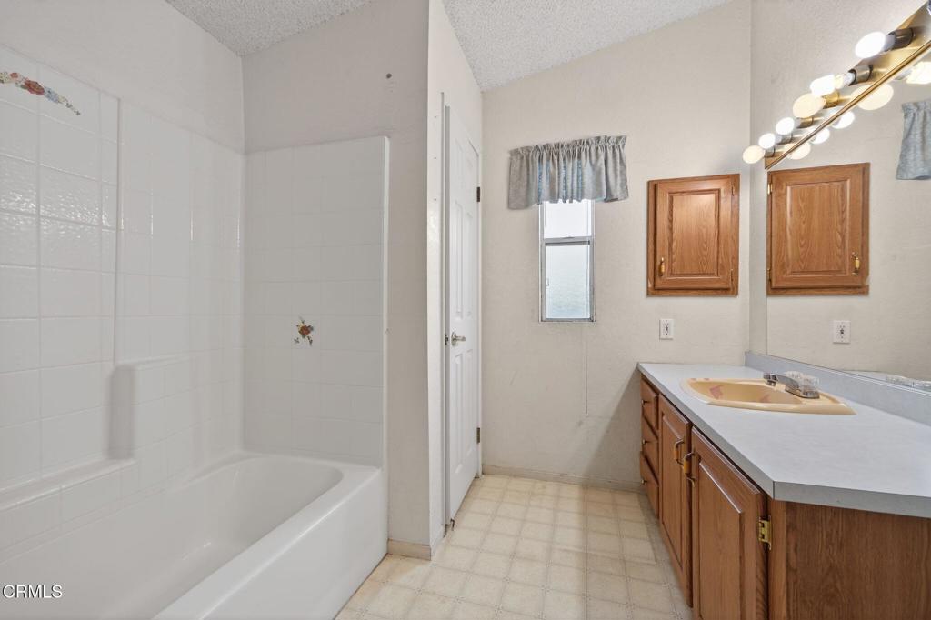 2177 Robin Avenue, Unit 2177A Oxnard, CA 93033 - Photo 24 of 29 a bathroom with a sink a mirror and a bathtub